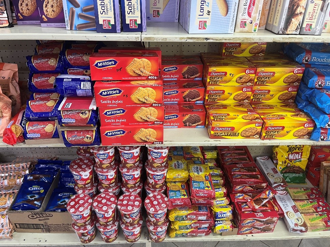 A supermarket shelf in Seychelles stocked with imported packaged biscuits and snacks.